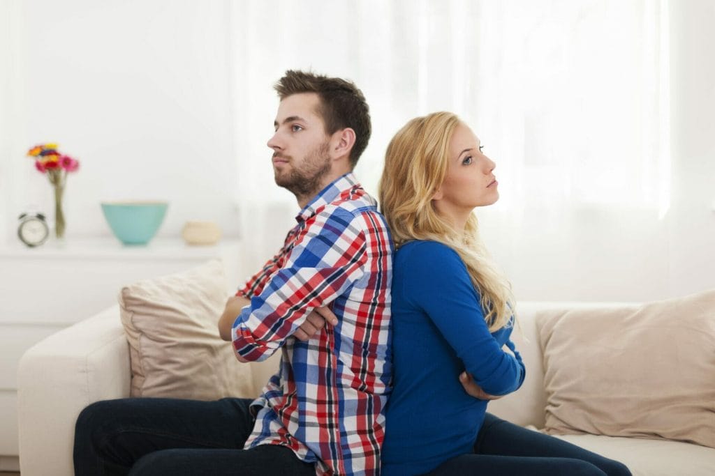 angry young couple sitting back back home